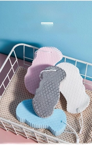 Detail of four soft bath sponges with fish scale texture and hanging cords in a basket