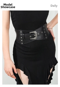 Close-up of wide elastic belt featuring vintage carved buckle and metal rivet details
