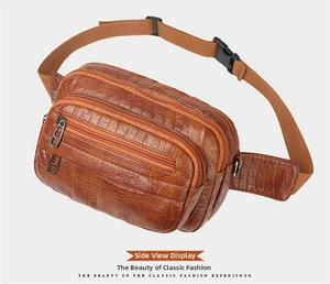 Détail latéral d'un sac banane marron à motif crocodile avec trois poches zippées