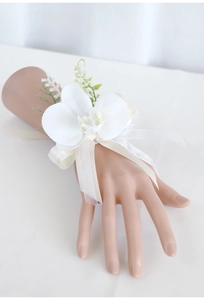Detail of white artificial orchid wrist corsage with ivory silk and organza ribbons
