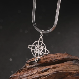 Détail du pendentif noeud de sorcière et rose sur une chaîne serpent en acier inoxydable