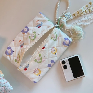 Detailed shot of quilted fabric bag with cute cat patterns, pearl strap and heart charm
