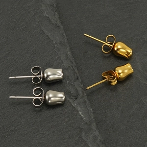 Polished stainless steel rose bud stud earrings in gold and silver set on grey stone