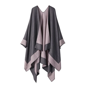 Detail showing the reversible knitted poncho texture with contrast grey and pink finish