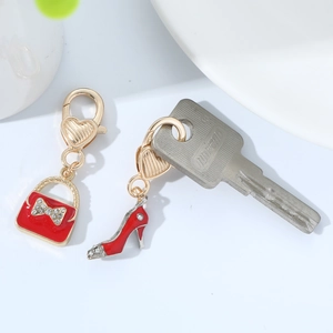 Detail of red enamel heart-shaped bag and high heel charms with sparkling rhinestones