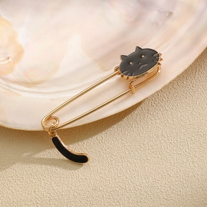 Detail of cute black enamel cat safety pin brooch with golden metal finish on pearl shell
