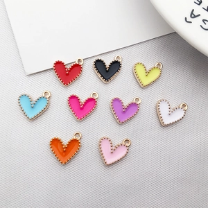Flat lay of colorful heart-shaped alloy pendants with gold beaded edges in nine vibrant hues