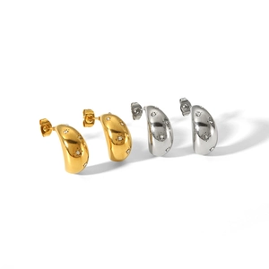 Minimalist 18k gold and silver teardrop earrings with starburst zircons on white backdrop
