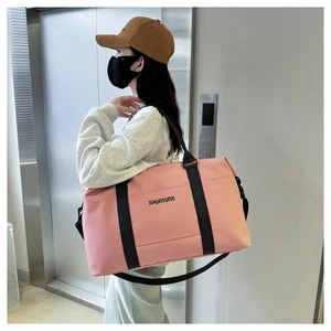 Pink oxford fabric travel bag with adjustable black shoulder strap in a lifestyle setting