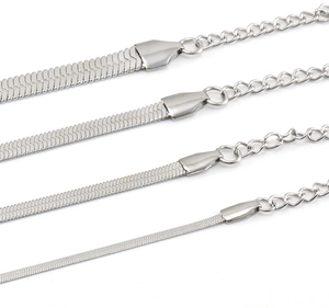 Primer plano de cuatro cadenas de serpiente de acero inoxidable plateado en varios grosores