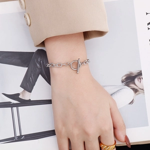 Silver stainless steel chain bracelet featuring a retro T-bar clasp worn on the wrist