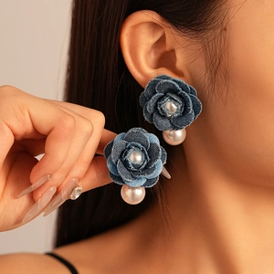 Detail of denim blue flower earrings with pearls and a vintage tassel design
