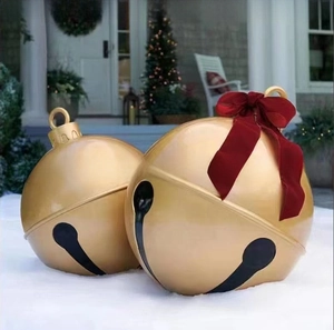 Close-up of golden outdoor Christmas bells with a large red velvet bow on snow