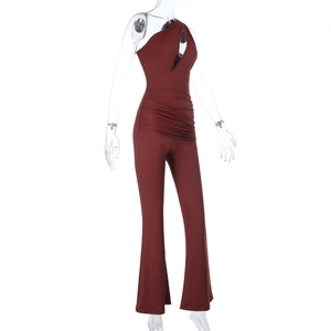 Detail view of burgundy one-shoulder jumpsuit with teardrop cutout and ruched waist details