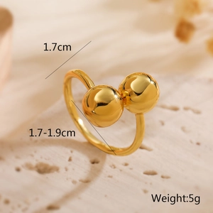 Detail shot of a polished 18K gold-plated bypass ring featuring 1.7cm double spheres