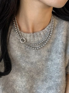 Close-up of double-layer silver grey pearl necklace with square zircon clasp worn on neck