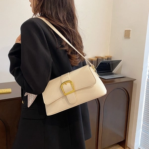Detail of a beige textured leather shoulder bag featuring a gold square buckle on the flap