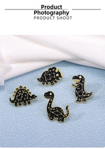 Détail de quatre broches dinosaures en émail noir avec motifs de constellations