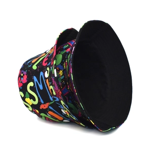 Detail view of reversible bucket hat showing colorful graffiti print and solid black side