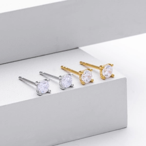Detail view of 925 sterling silver four-prong stud earrings in gold and silver finish