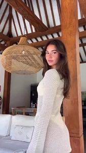 Detalle de vestido playero blanco de ganchillo con diseño calado y mangas acampanadas