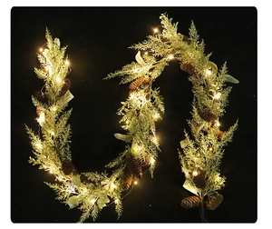 Close-up of lighted pine needle garland with natural pine cones and warm LED lights