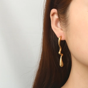 Boucles d'oreilles pendantes dorées avec design vagues et finition mate