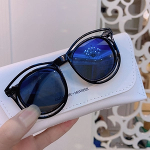 Detail of vintage black frames with blue lenses and branded faux leather glasses case