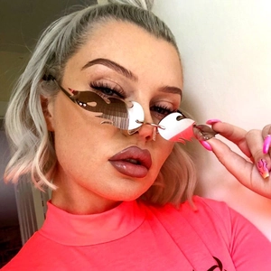 Silver flame-shaped rimless sunglasses shown on a person for creative party styling