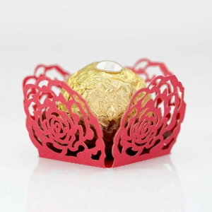 Detail of red laser-cut hollow rose pattern paper chocolate holder for wedding party decor