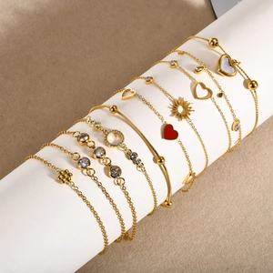 Détail de bracelets en acier inoxydable doré 18K avec breloques en zircone sur présentoir