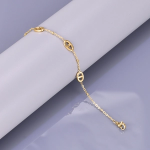 Macro shot of gold-plated pig nose link chain bracelet with lobster clasp on a pedestal