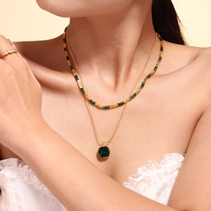 Collana a doppio strato dorata con pendente in pietra naturale verde e perline su modella