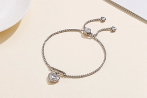 Macro detail of adjustable heart pendant bracelet in silver-tone stainless steel finish