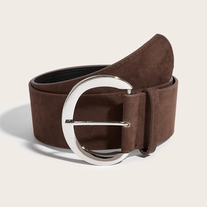 Détail d'une large ceinture en daim marron avec une grande boucle circulaire argentée