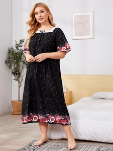 Detail of square neckline with white lace trim and small black bow on floral nightdress