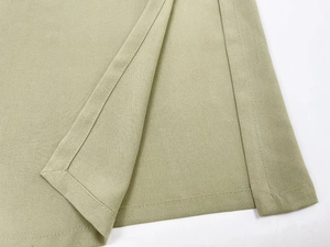 Nahaufnahme der sauberen Nähte und der Twill-Textur am Saum eines olivgrünen Seidenkleides