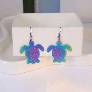 Close-up of rainbow gradient sea turtle drop earrings with decorative bead hooks