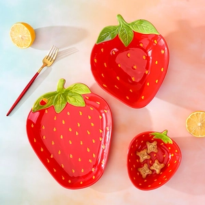 Creative strawberry-shaped ceramic tableware set including bowls and plate on gradient background