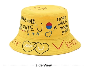 Side view of yellow canvas bucket hat featuring colorful graffiti and street style prints