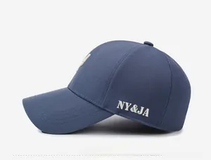 Detail of NY&JA letter embroidery on navy blue baseball cap with stitched brim
