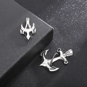 Macro detail of silver skull anchor pendant and geometric charm with rope textures