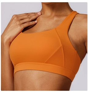 Dettaglio del reggiseno sportivo arancione con cuciture piatte e tessuto elastico opaco