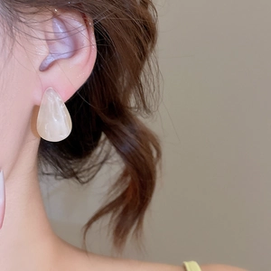 Gros plan de boucles d'oreilles goutte en acrylique marbré pour un style minimaliste