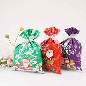 Three-piece Christmas drawstring gift bags in red, green, and purple with white ribbons