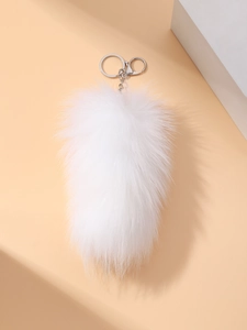 Detail showing plush white faux fox fur tail keychain with silver metal lobster clasp