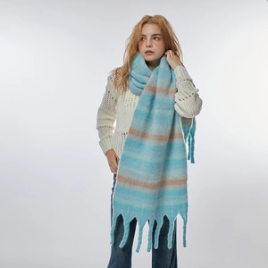 Soft plush blue and orange striped winter scarf with tassels shown on a model