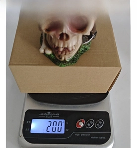 Detailed view of skull figurine with floral accents on a scale showing 200g weight