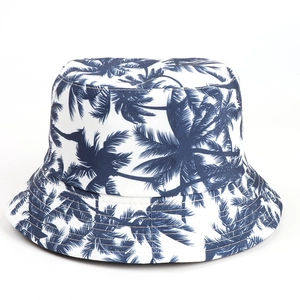 Detail of white cotton bucket hat featuring navy blue palm tree leaf prints and fine stitching