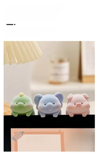 Close-up of cute pink pig, blue elephant, and green dinosaur monitor edge decor figurines